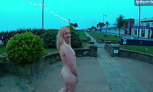 Young blonde exhibitionist become man walking divest with reference to Felixstowe seafront, England