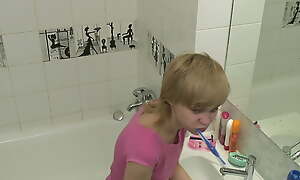 Teen girl's morning hygiene in a difficulty lavatory