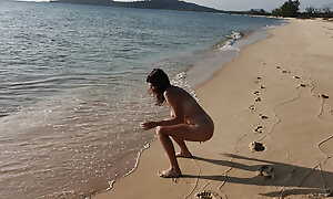Cute teen peeing on a public beach obstruction
